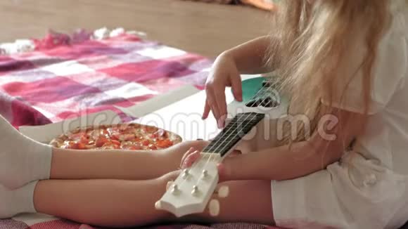 学龄前女孩在房间里坐在地板上吃披萨视频的预览图