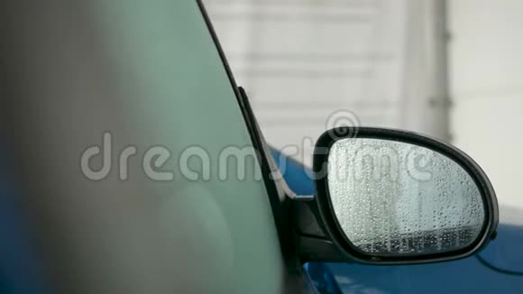 汽车后视镜上覆盖着水滴特写关上车门的概念视频的预览图