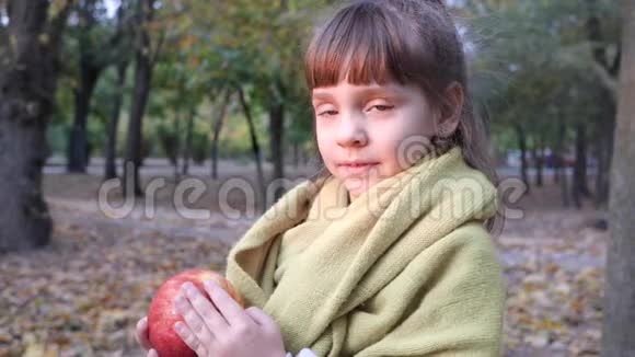 秋园露天吃大红苹果的帅气小女孩视频的预览图