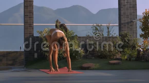 苗条的女人站在露台上的瑜伽平衡姿势视频的预览图