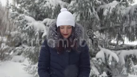 快乐的女人喜欢在冬天的森林里下雪在新鲜空气中行走视频的预览图