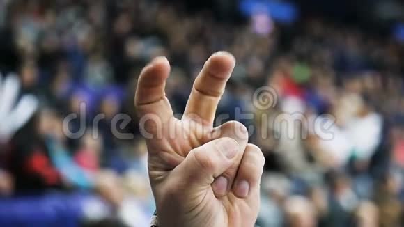 特写体育迷在比赛中用手指显示胜利的象征视频的预览图