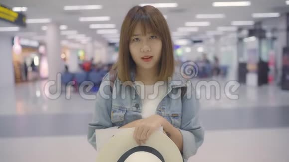 快乐的亚洲女人在国际机场候机楼里微笑着拍照女游客准备去度假视频的预览图