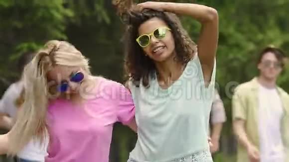 两个精力充沛的快乐女孩一起随着音乐跳舞在户外聚会上玩得很开心视频的预览图