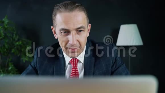 坐在笔记本电脑前工作的商人或律师视频的预览图