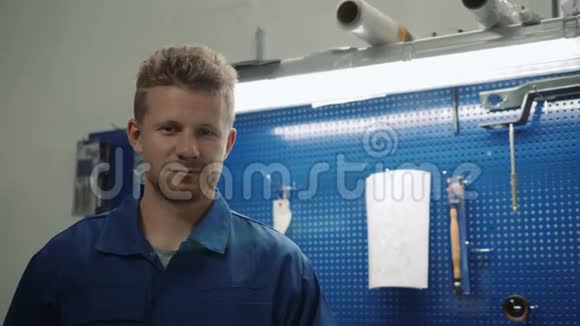一位汽车修理工在修车厂工作时的画像一个微笑的人在工厂仓库里视频的预览图
