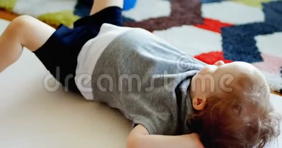 父亲在婴儿躺在地毯上锻炼身体视频的预览图