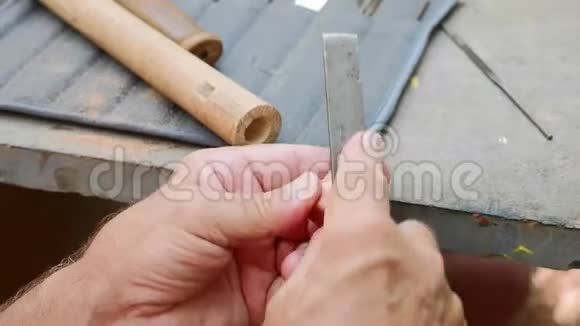 老人用锉刀把软木塞磨成手工长笛特写视频的预览图