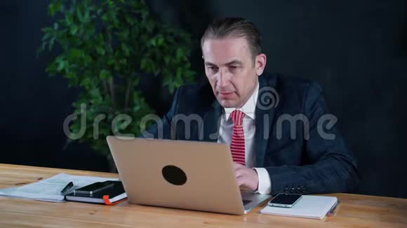 为笔记本电脑在办公室工作的商人或律师视频的预览图