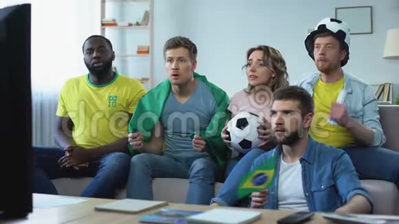 快乐的巴西朋友在家看比赛庆祝足球队进球视频的预览图