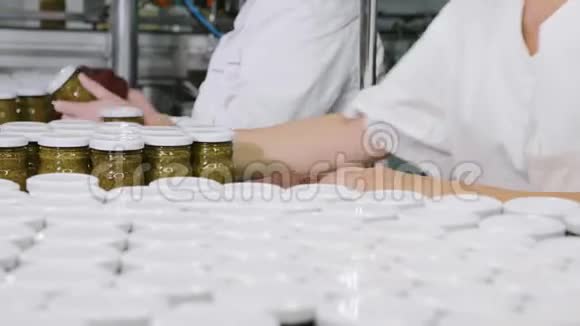工作人员在传送带上贴上标签之前先用Pesto酱擦拭一个玻璃瓶然后特写视频的预览图