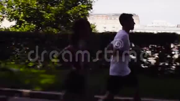 女人和男人在河边的城市里奔跑视频的预览图