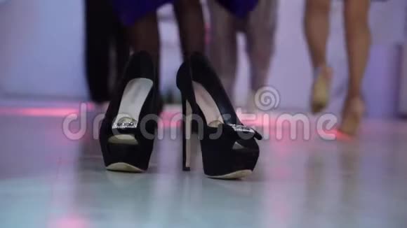 人们在舞会上跳舞没有鞋子的女人赤脚玩得开心她的黑鞋在前台个人视频的预览图