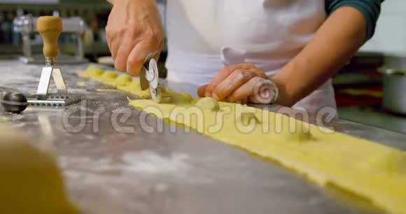 4k面包店的男面包师使用比萨饼切割器视频的预览图