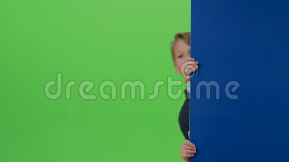 少年从墙后走出来在绿色的屏幕上向自己招手视频的预览图