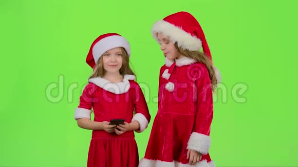 两个穿新年服装的孩子在电话里自拍绿色屏幕慢动作视频的预览图