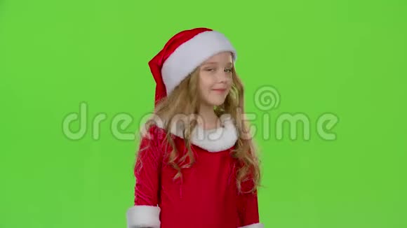 穿着红色西装的圣诞老人助手正站在房间里眨眼绿色屏幕视频的预览图