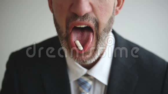 嘴里含药丸的男人特写镜头视频的预览图