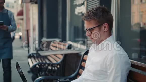 在户外街头长椅咖啡馆通过手机NFC技术付款的人视频的预览图