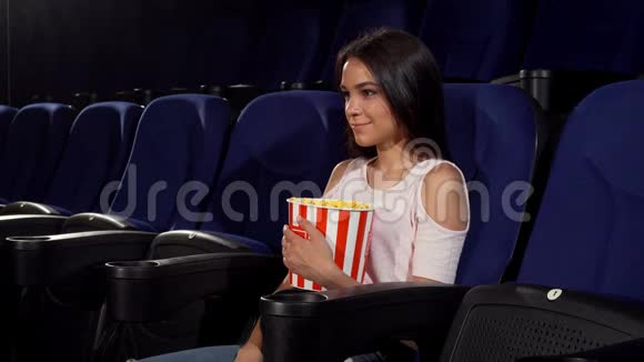 在电影院里美丽快乐的女人对着镜头微笑视频的预览图