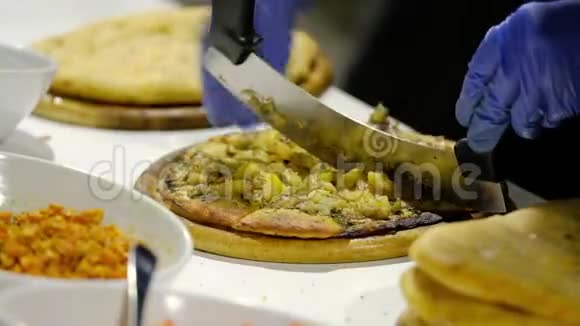 厨师面包师在厨房切素食披萨的特写视频的预览图