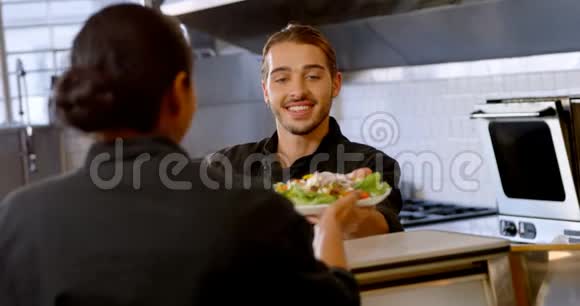 男厨师将餐盘交给女服务员4k视频的预览图