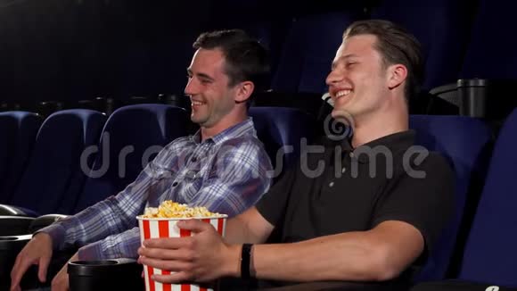 两个男朋友在电影院看喜剧时大笑视频的预览图