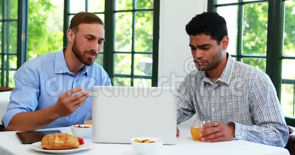 男性高管在笔记本电脑4k时品尝果汁杯视频的预览图