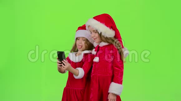 孩子们的小家伙们在智能手机上展示舌头做脸做自拍绿色屏幕慢动作视频的预览图