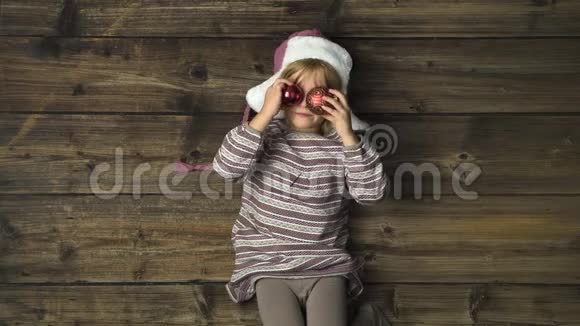 头顶上幸福微笑的女孩子戴着帽子玩着老式木制背景上的装饰品文字或徽标复制空间视频的预览图