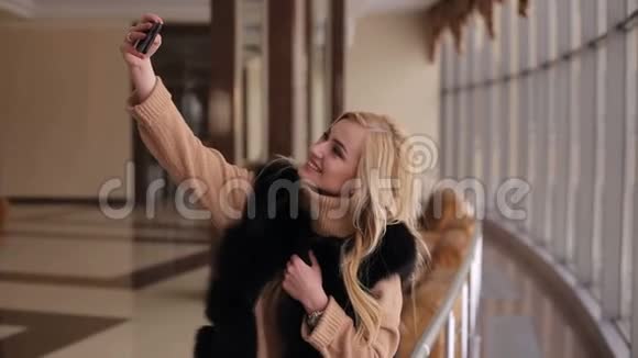 穿皮大衣的女孩在酒店大堂自拍视频的预览图