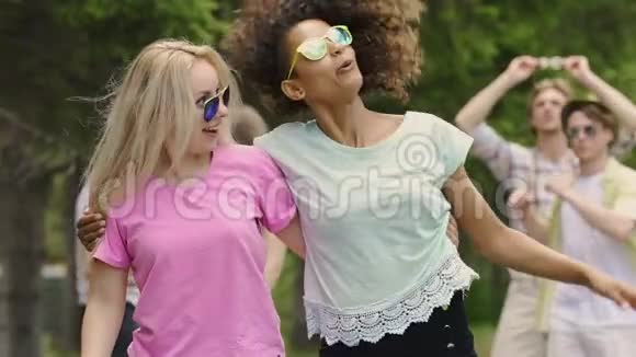 两个女人在公园里和朋友跳舞拥抱享受音乐会青春洋溢视频的预览图