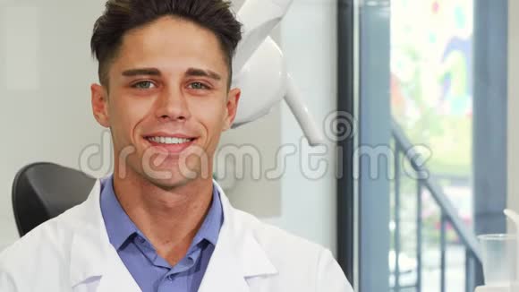 迷人的男性牙医微笑着拿着牙刷视频的预览图