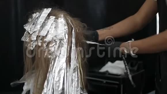 土耳其发型师从一个年轻模特的彩绘头发上移除了箔纸视频的预览图