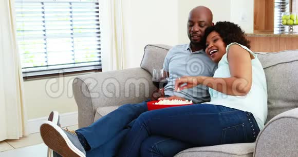 一对夫妇在客厅4k看电视时吃零食视频的预览图