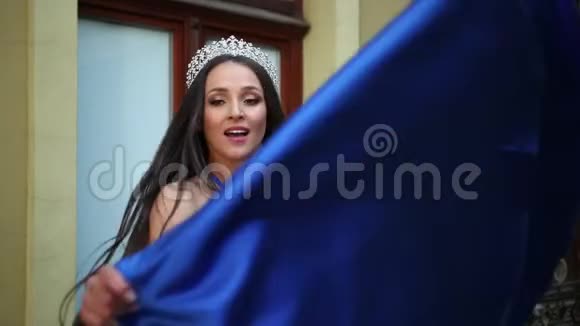 女孩黑发穿着一件蓝色连衣裙领口很深摆着一顶皇冠视频的预览图