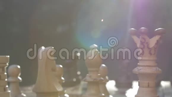 桌上的木制象棋在镜头耀斑下从左到右靠太阳滑动视频的预览图