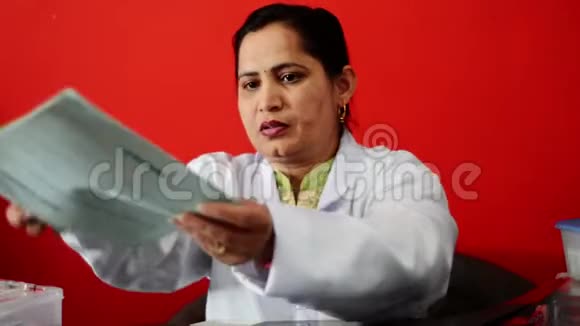 年轻的印度医生坐在她的诊所里视频的预览图