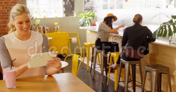 女性高管在使用数码平板电脑4k的时候吃奶昔视频的预览图