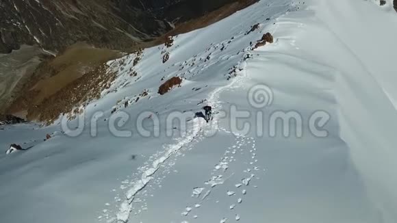 登山者在山上攀登一座雪岭实现目标视频的预览图