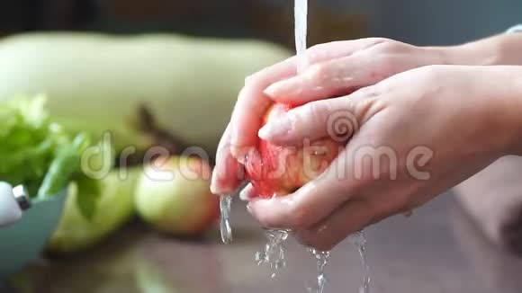 年轻的素食主义者洗红苹果手拿新鲜水果下自来水厨房水槽健康生活方式视频的预览图