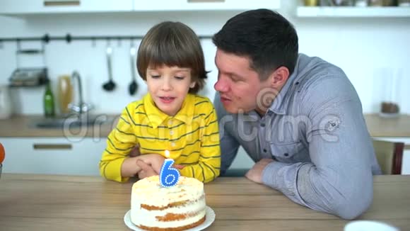 非常可爱的男孩用蛋糕和快乐的父亲庆祝他的生日六年生日快乐小男孩吹了视频的预览图