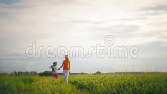 妈妈和女儿在一片花田里幸福的家庭母子女儿在花上玩得很开心快乐的女儿视频的预览图