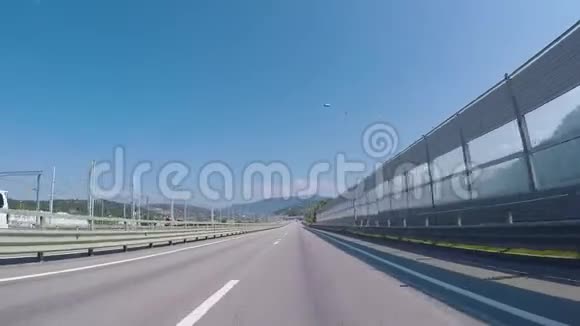 从郊区公路上的汽车上看到场景高速公路在城市入口处美丽的沥青路山在视频的预览图