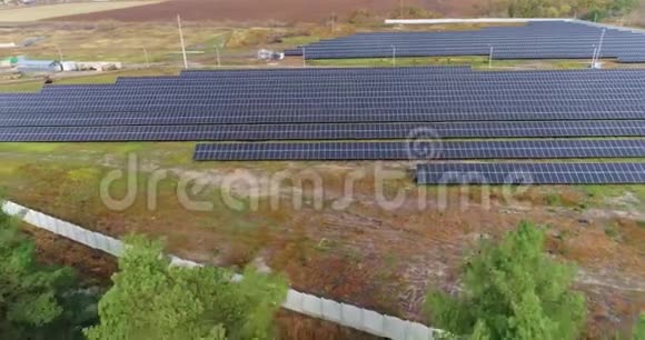 从上面可以看到太阳能发电站在森林附近的一个大型太阳能发电站上空飞行视频的预览图