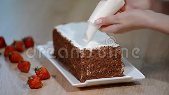 糖果女人把奶油放在蛋糕上完成糕点视频的预览图