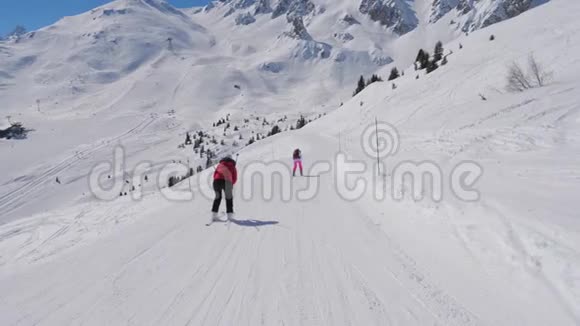 两个女滑雪者在冬季滑下理想的山坡视频的预览图