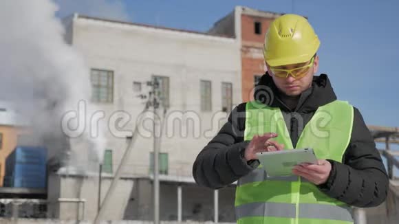 戴安全帽的工程师正在一家工业工厂使用平板电脑视频的预览图
