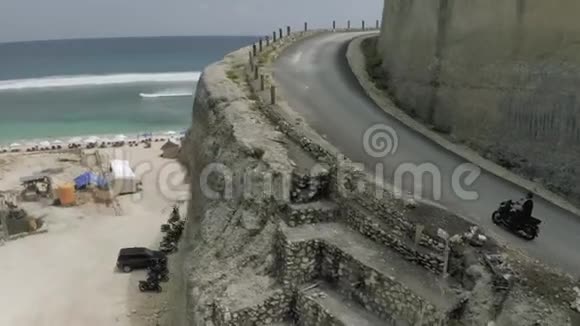在UluwatuBali海滩和岩石的公路上骑自行车视频的预览图