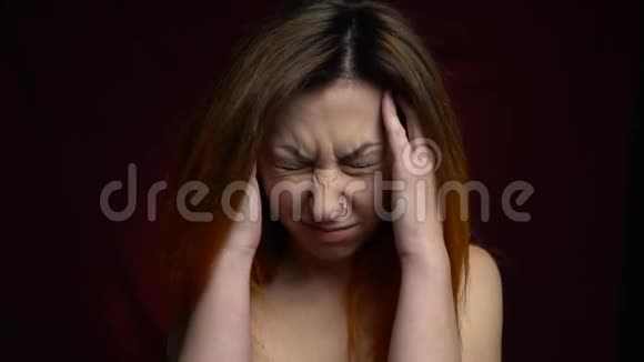 红发女子穿刺头患有偏头痛并抱着头视频的预览图